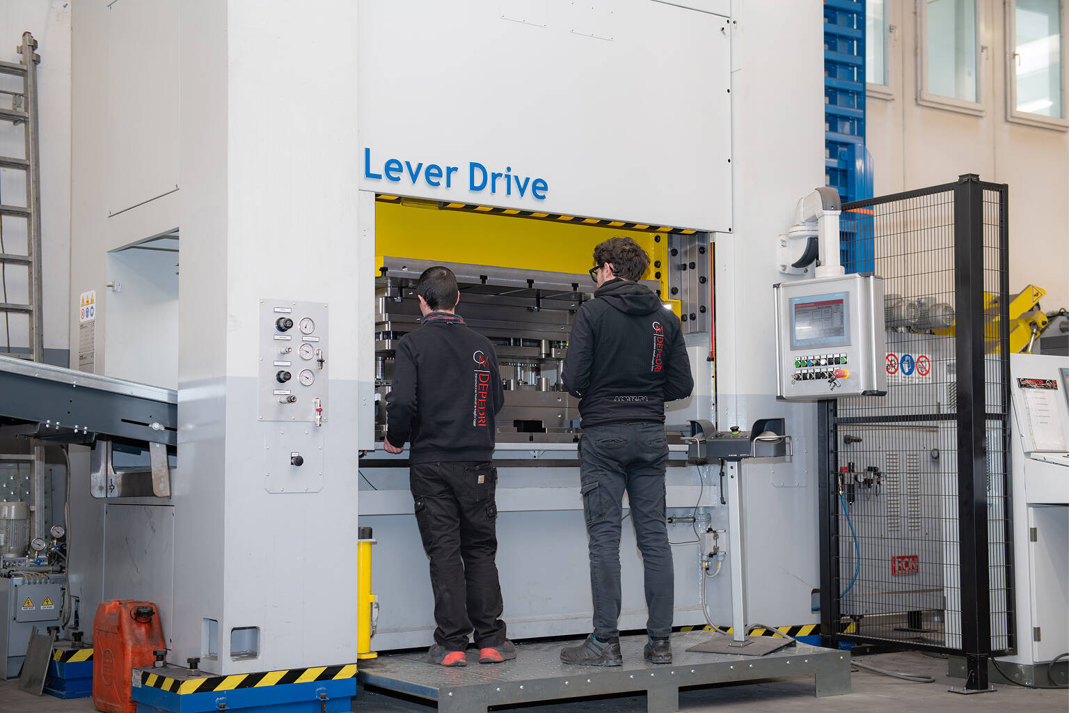 Due tecnici operano un macchinario industriale Lever Drive in un'officina