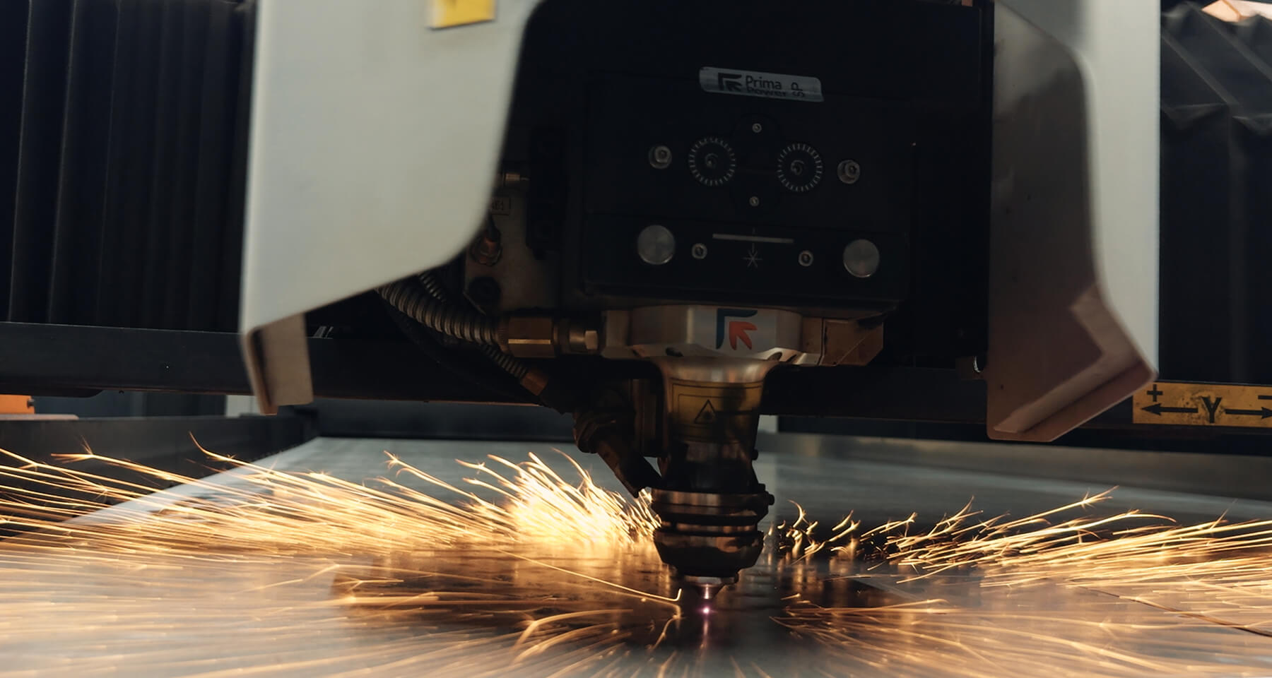 Taglio laser di una lastra di metallo con scintille in un ambiente industriale