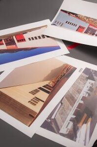 Stampe fotografiche di architettura moderna sparse su una superficie grigia