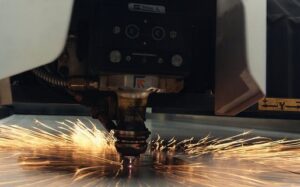 Macchina per il taglio laser che lavora una lamiera metallica con scintille